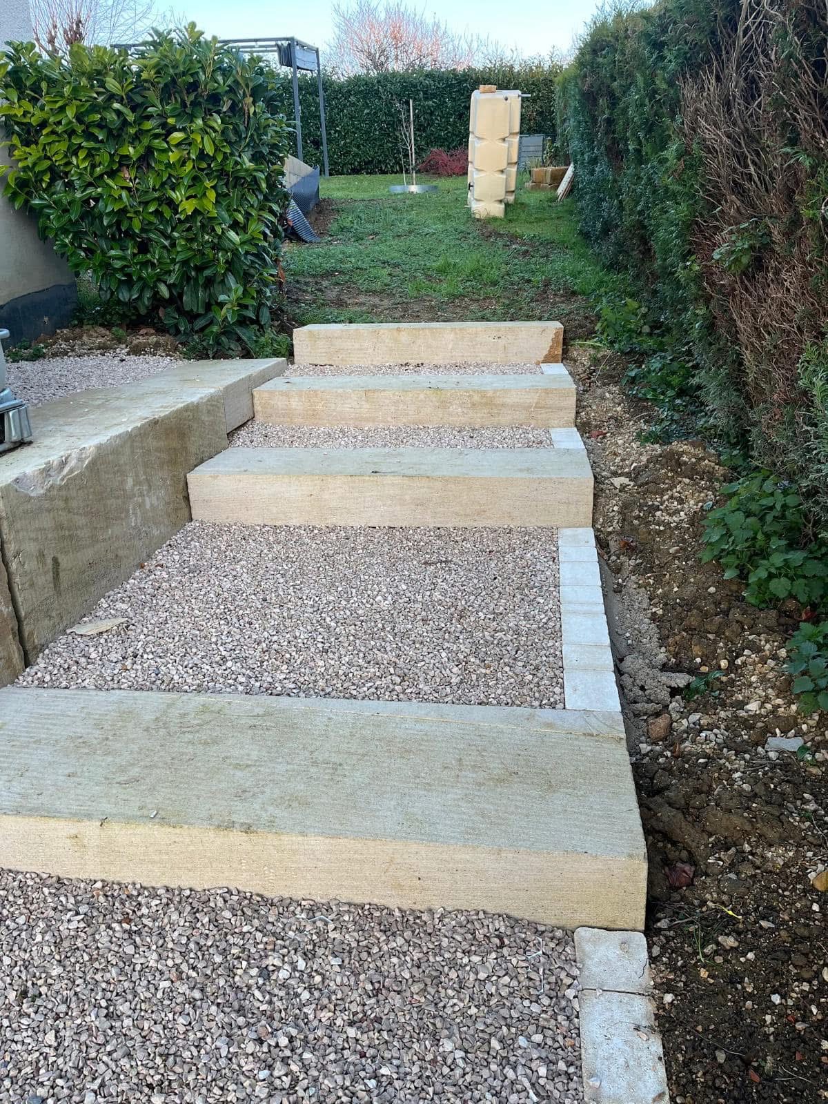 Escalier extérieur en blocs de pierre massive et paliers en gravier